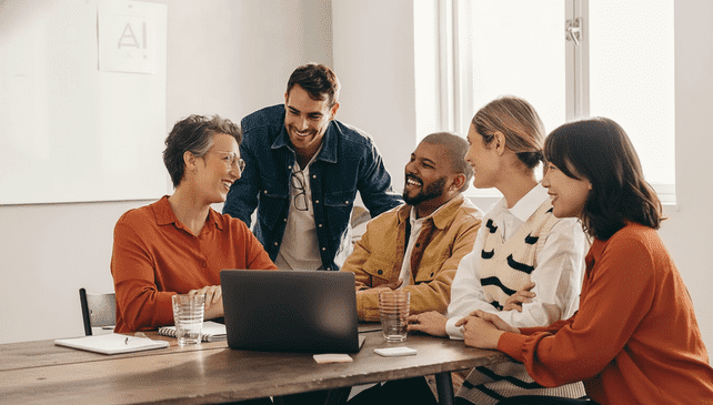 Colleagues gathered around a laptop